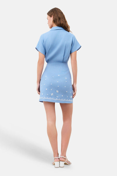 Robe chemise bleue de CAROLL avec broderie florale blanche, col et manches courtes, vue arrière.