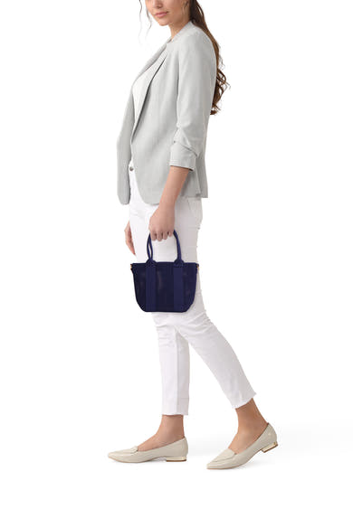 Marineblauwe schoudertas van Access® in geperforeerd mesh met handvatten, vastgehouden door een vrouw in een grijze blazer.