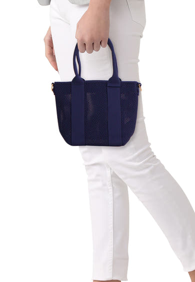 Blauwe schoudertas van Access® van mesh, gedragen door een persoon in een witte broek.