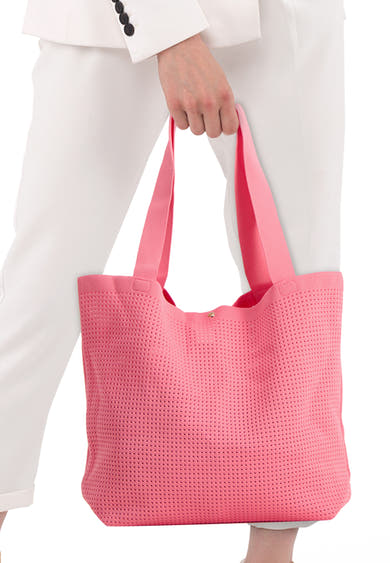 Sac à bandoulière rose perforé de Access®, tenu par une personne en blazer blanc et pantalon.