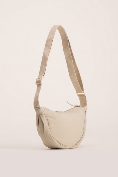 Sac à bandoulière écru d'Access®, avec une bandoulière réglable et une texture lisse.

