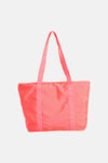 Sac à bandoulière rose de Access® en tissu brillant avec de longues anses, vue de face.