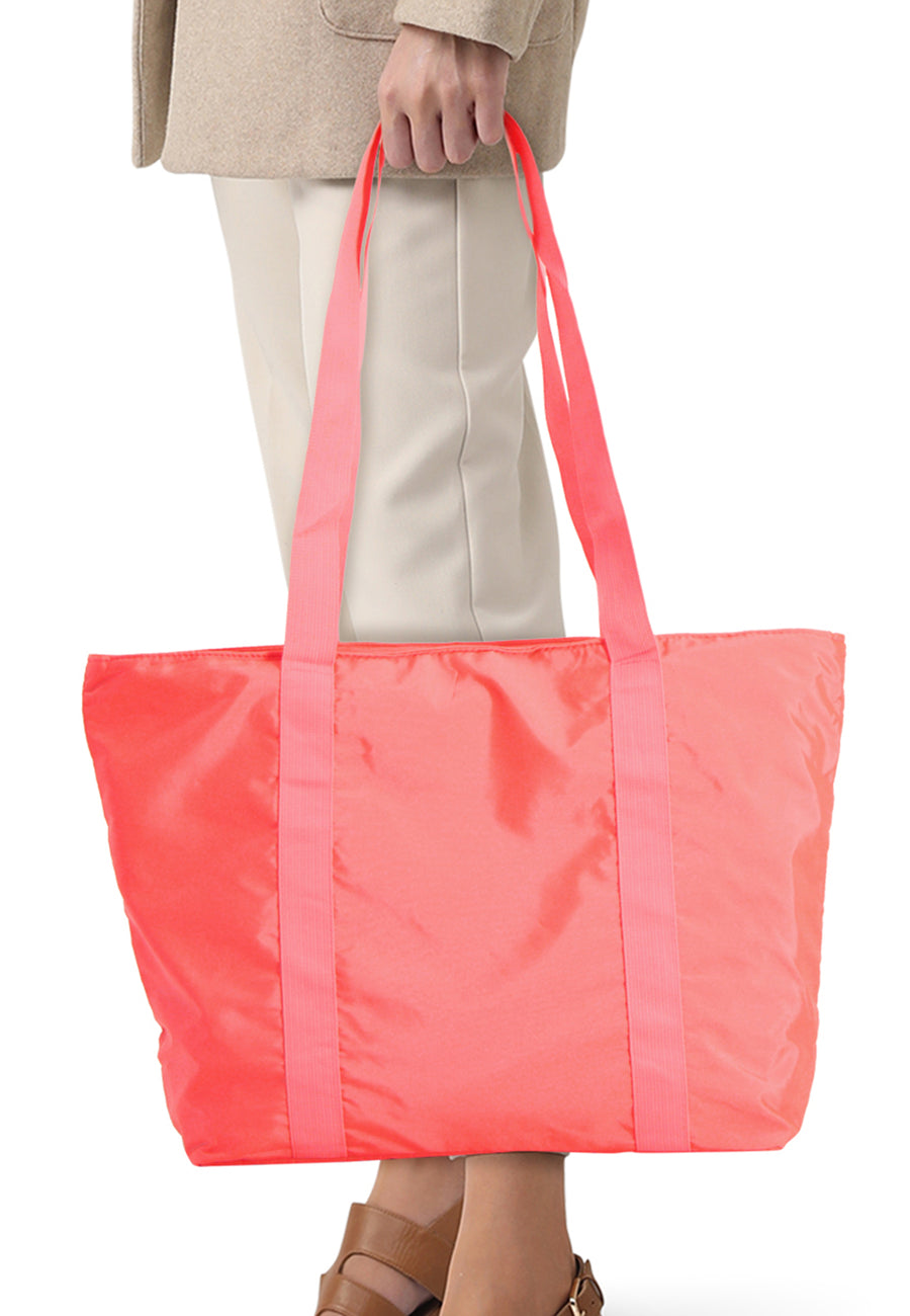 Sac à bandoulière rose de Access®, rectangulaire en tissu léger, porté à la main.