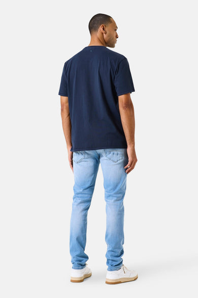 Garcia lichtblauwe denim slim fit jeans, met stijlkenmerken en gedragen met een marineblauw T-shirt.