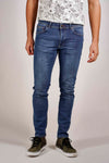 Blauwe slim fit jeans van Petrol Industries, gedragen met een T-shirt met bloemenprint en kaki hoge sneakers.