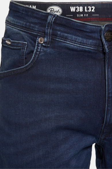 Jean slim en denim bleu foncé de Petrol Industries, avec coutures apparentes et détails de la marque sur la poche.