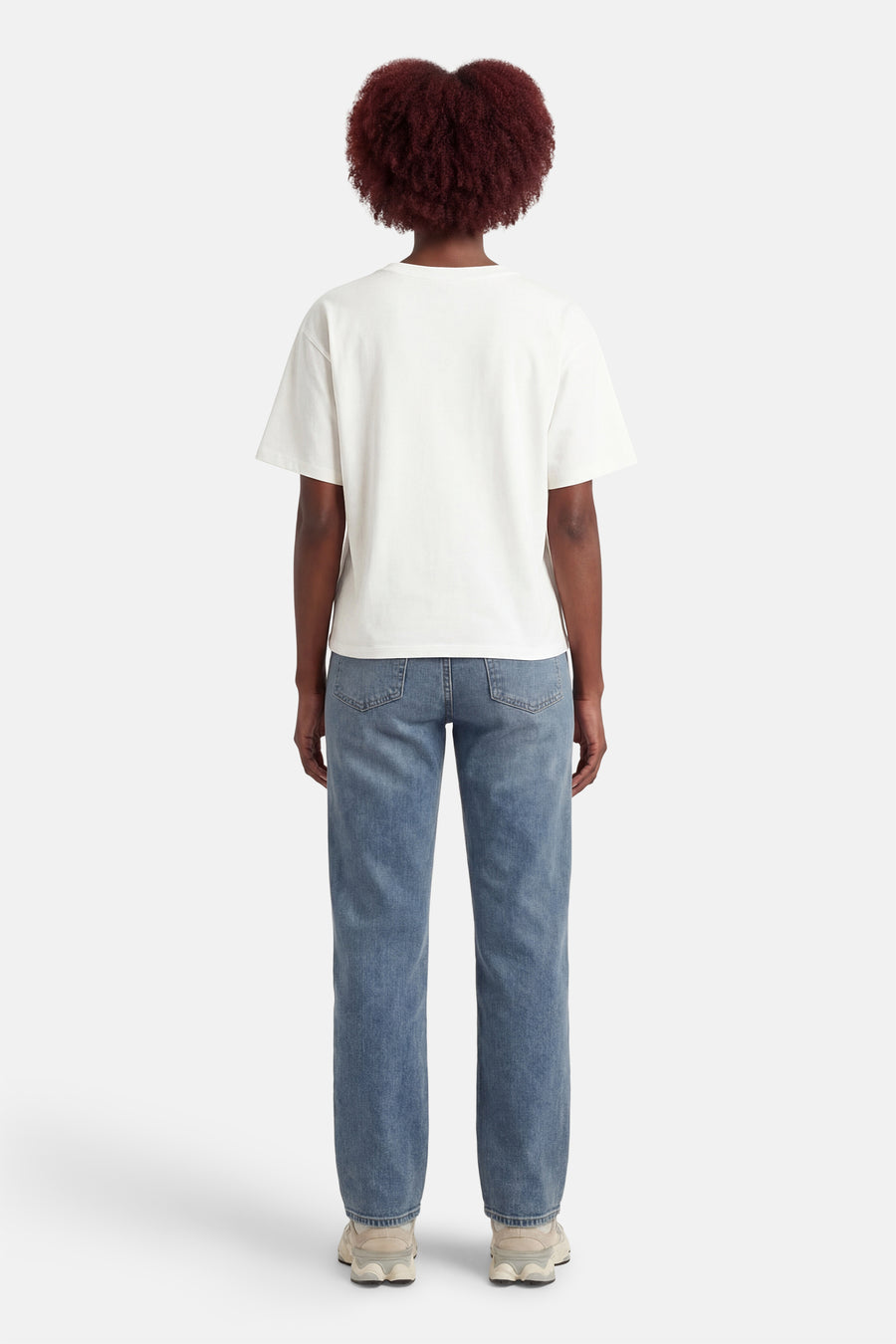 T-shirt à manches courtes blanc par ADORE, porté avec un jean bleu et des baskets beiges, vue de dos.
