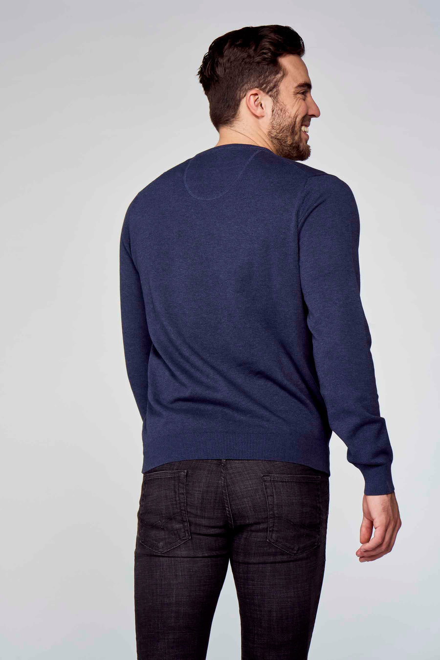 Pull col V bleu de Fynch-Hatton, porté avec un jean noir, vue de dos.