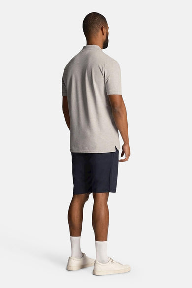 Bermuda blauw van LYLE & SCOTT, gedragen met een grijs polo, witte sokken en creme baskets.