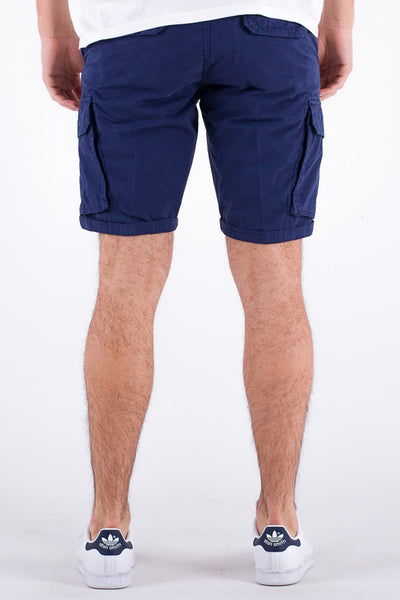 Bermuda bleu marine de LYLE & SCOTT, poches cargo latérales, porté avec un t-shirt blanc et des baskets blanches.