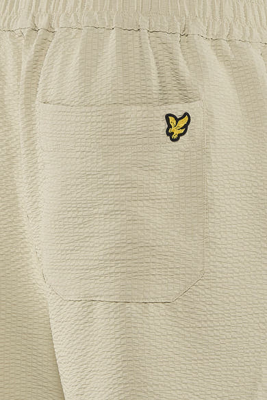 Korte beige textuurshorts met ruitpatroon van LYLE & SCOTT, met achterzak en geborduurd goudkleurig adelaarslogo, achterzijde.