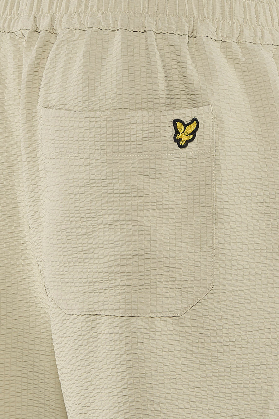Korte beige textuurshorts met ruitpatroon van LYLE & SCOTT, met achterzak en geborduurd goudkleurig adelaarslogo, achterzijde.