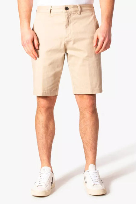 Korte beige short van LYLE & SCOTT, gedragen met witte sneakers, op een witte achtergrond.