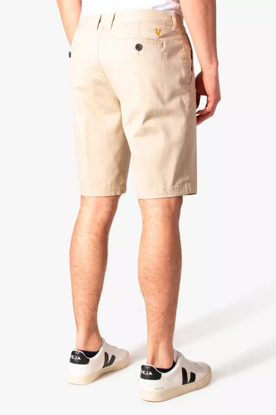 Korte beige short van LYLE & SCOTT, met een achterzak met knoop en gedragen met witte sneakers.