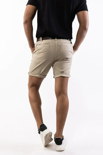 Short beige de PRESLY & SUN, coupe chino avec revers, porté avec un t-shirt noir et des baskets blanches.