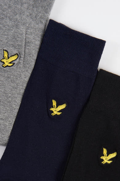 Chaussettes grises de LYLE & SCOTT, avec des logos d'aigle brodés en jaune, texture tricotée.