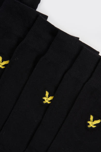 Chaussettes noires de LYLE & SCOTT, avec un logo brodé d'oiseau jaune sur le côté.