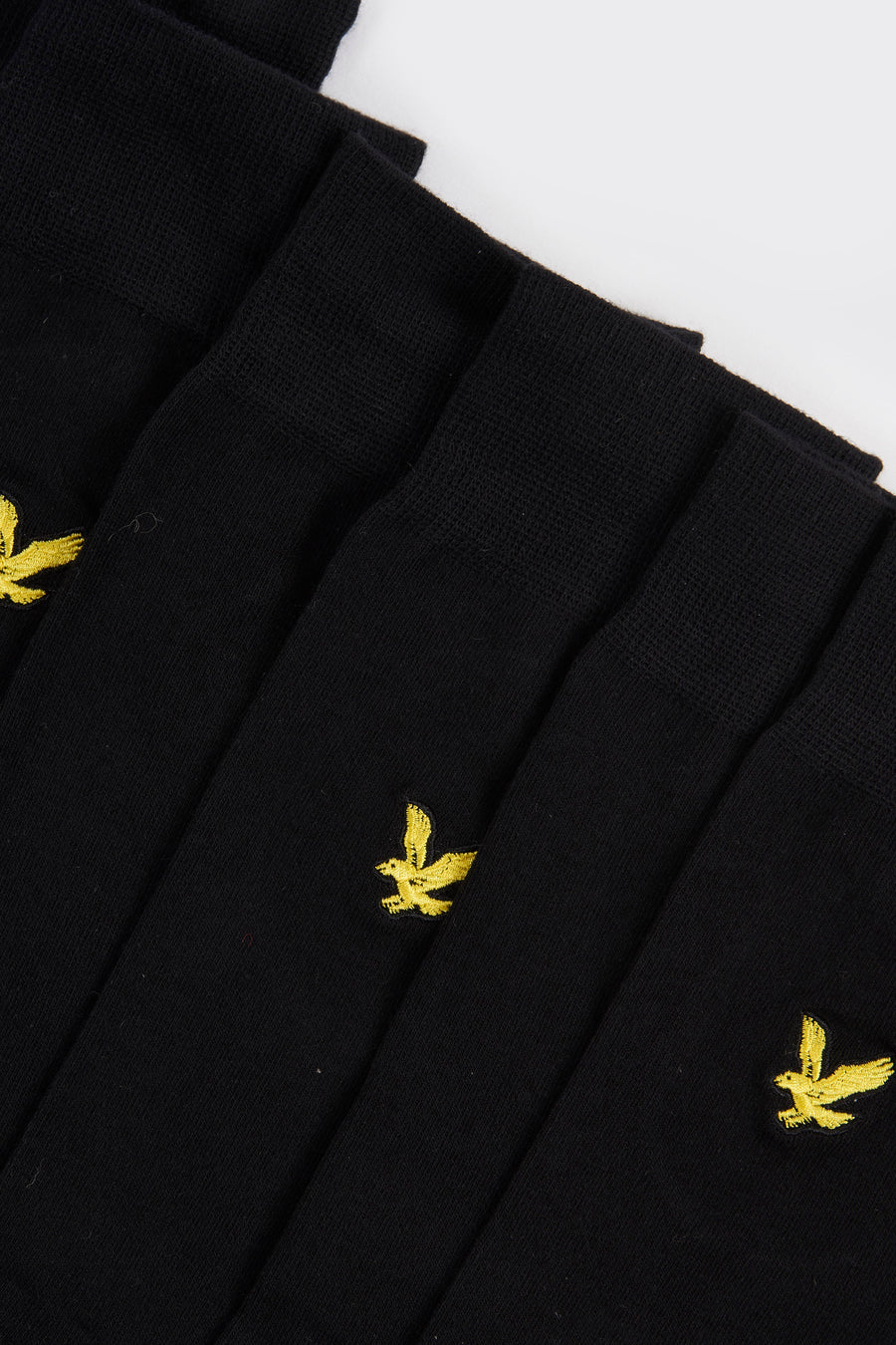 Chaussettes noires de LYLE & SCOTT, avec un logo brodé d'oiseau jaune sur le côté.