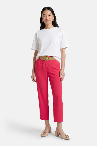 Roze broek van ZABAIONE, met een gevlochten riem, gedragen met een effen wit T-shirt en beige hakken.