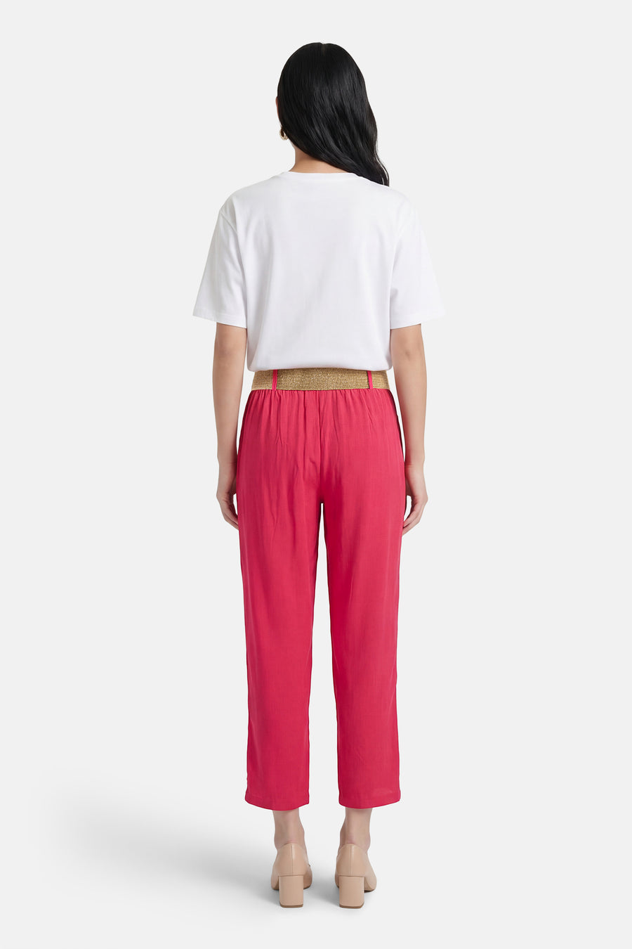 Roze broek van ZABAIONE met gouden riem, gedragen met een wit T-shirt en huidkleurige hakken.