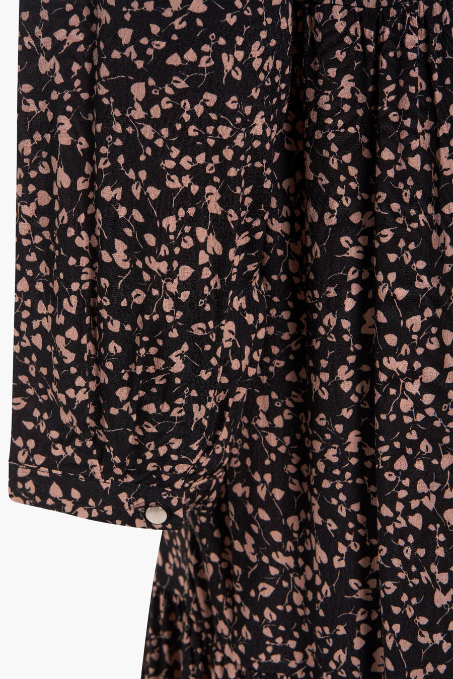 Zwarte jurk met lange mouwen van Zabaione, met een beige bloemenpatroon en een knoopsluiting bij de manchet.