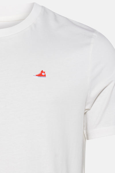 T-shirt blanc à manches courtes de STROM, avec motif discret d'une basket rouge.
