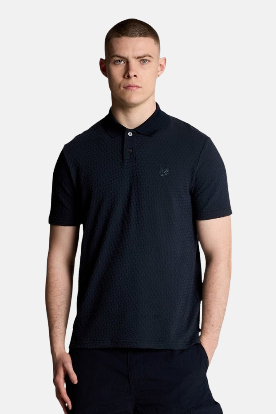 Marineblauw poloshirt met korte mouwen van LYLE & SCOTT, met subtiel textuurpatroon en discreet logo.