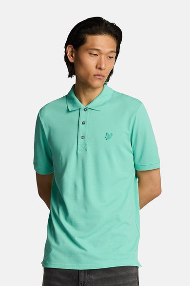 Turquoise poloshirt met korte mouwen van LYLE & SCOTT, van achteren gezien, gedragen met een lichtgrijze jeans.