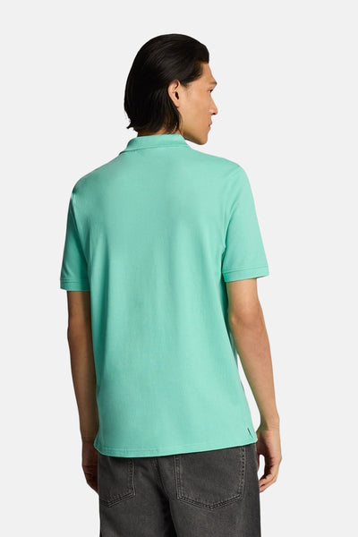 Polo turquoise à manches courtes de LYLE & SCOTT, vu de dos, porté avec un jean gris délavé.