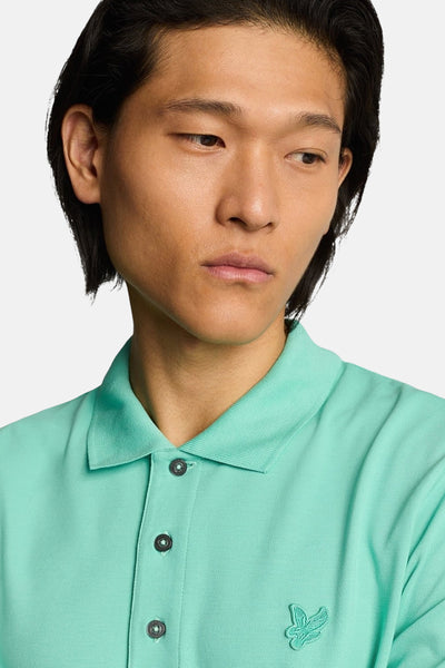 Turquoise poloshirt met korte mouwen van LYLE & SCOTT met donkere knopen en een klein geborduurd logo.