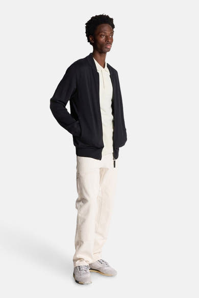 Grijs poloshirt met korte mouwen van LYLE & SCOTT, gedragen met een zwart jasje en een witte broek.
