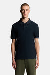 Polo bleu à manches courtes de LYLE & SCOTT, porté avec un pantalon kaki, sur fond blanc.