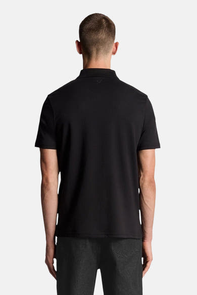 Zwart poloshirt met korte mouwen van LYLE & SCOTT, achterkant, gedragen met een donkere broek.