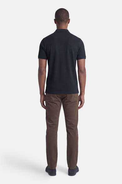 Polo à manches courtes bleu de LYLE & SCOTT, vu de dos, porté avec un pantalon marron en velours côtelé.