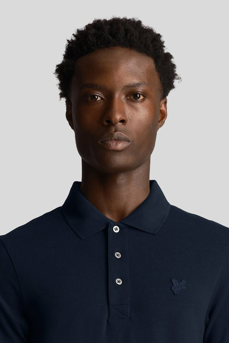 Polo à manches courtes bleu marine de LYLE & SCOTT, avec trois boutons et logo discret sur la poitrine.