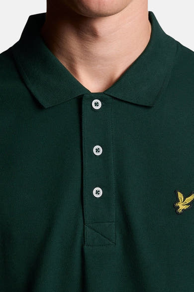 Polo vert de LYLE & SCOTT en maille piquée, avec trois boutons blancs et aigle brodé doré.