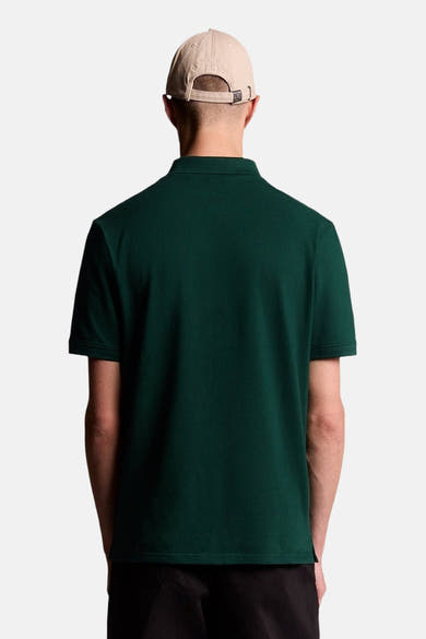Groen POLO van LYLE & SCOTT, achterkant, gedragen door een man met een beige pet en een donkere broek.