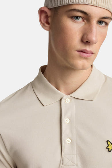 Polo beige à manches courtes de Lyle & Scott avec trois boutons et logo brodé.