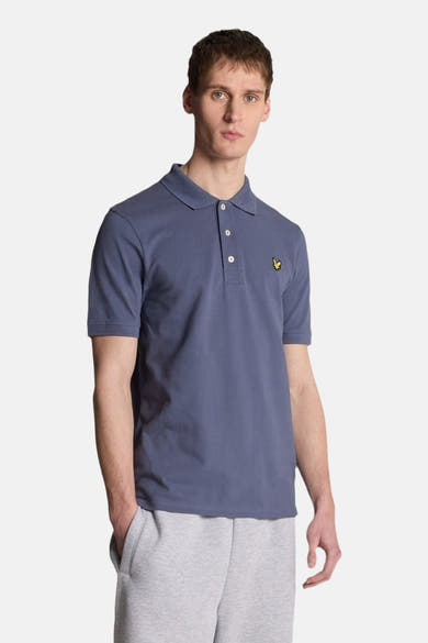 Blauwe polo met korte mouwen van LYLE & SCOTT, achterkant, gedragen met een grijze joggingbroek.