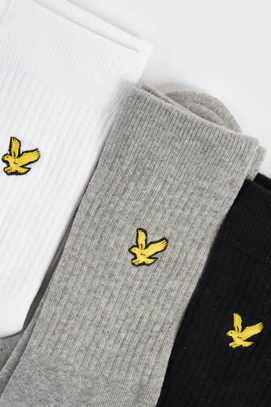 Chaussettes blanches de LYLE & SCOTT, grises et noires, avec logo brodé d'un aigle jaune.
