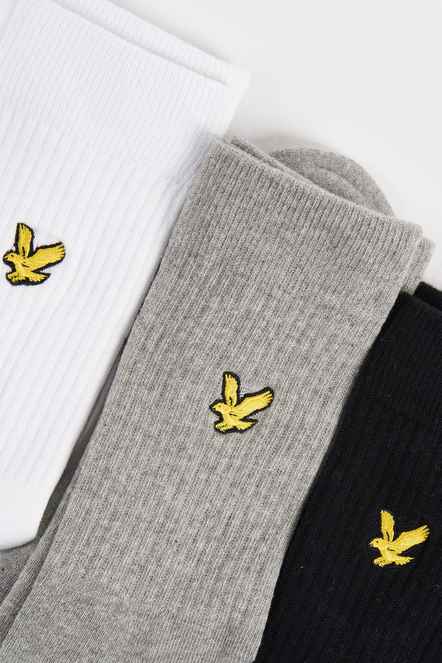 Chaussettes blanches de LYLE & SCOTT, grises et noires, avec logo brodé d'un aigle jaune.
