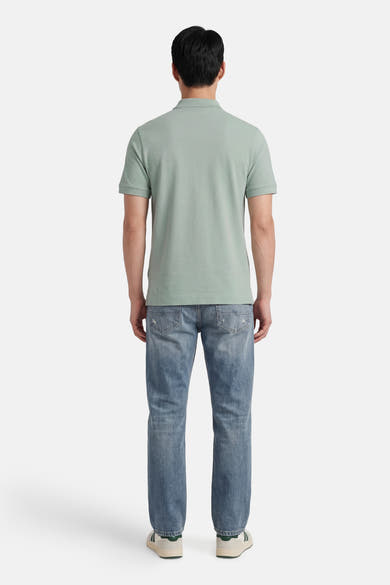 Lichtgroen STROM poloshirt met korte mouwen, van achteren gedragen met een verbleekte spijkerbroek en sneakers.