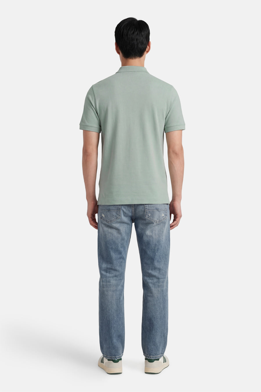 Lichtgroen STROM poloshirt met korte mouwen, van achteren gedragen met een verbleekte spijkerbroek en sneakers.