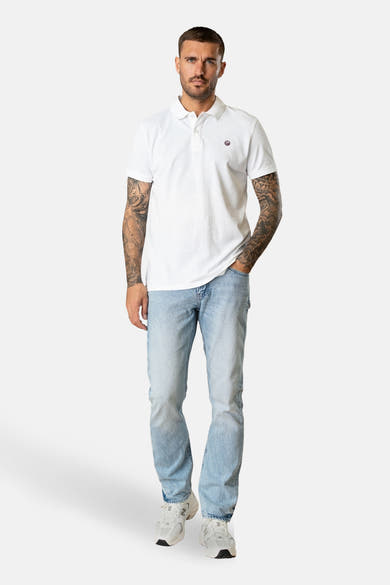Rechte lichtblauwe spijkerbroek van Petrol Industries, gedragen met een witte polo en witte sneakers.