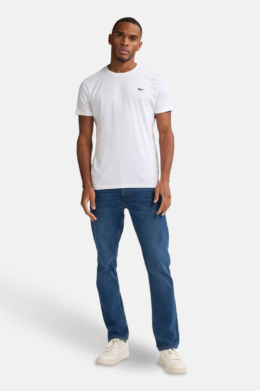 Middelblauwe rechte jeans van Petrol Industries, gedragen met een wit T-shirt en witte sneakers.