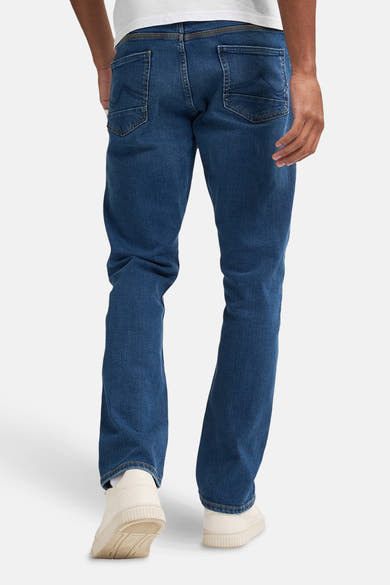Jean droit bleu moyen de Petrol Industries, vue arrière, porté avec des baskets blanches et un t-shirt blanc.