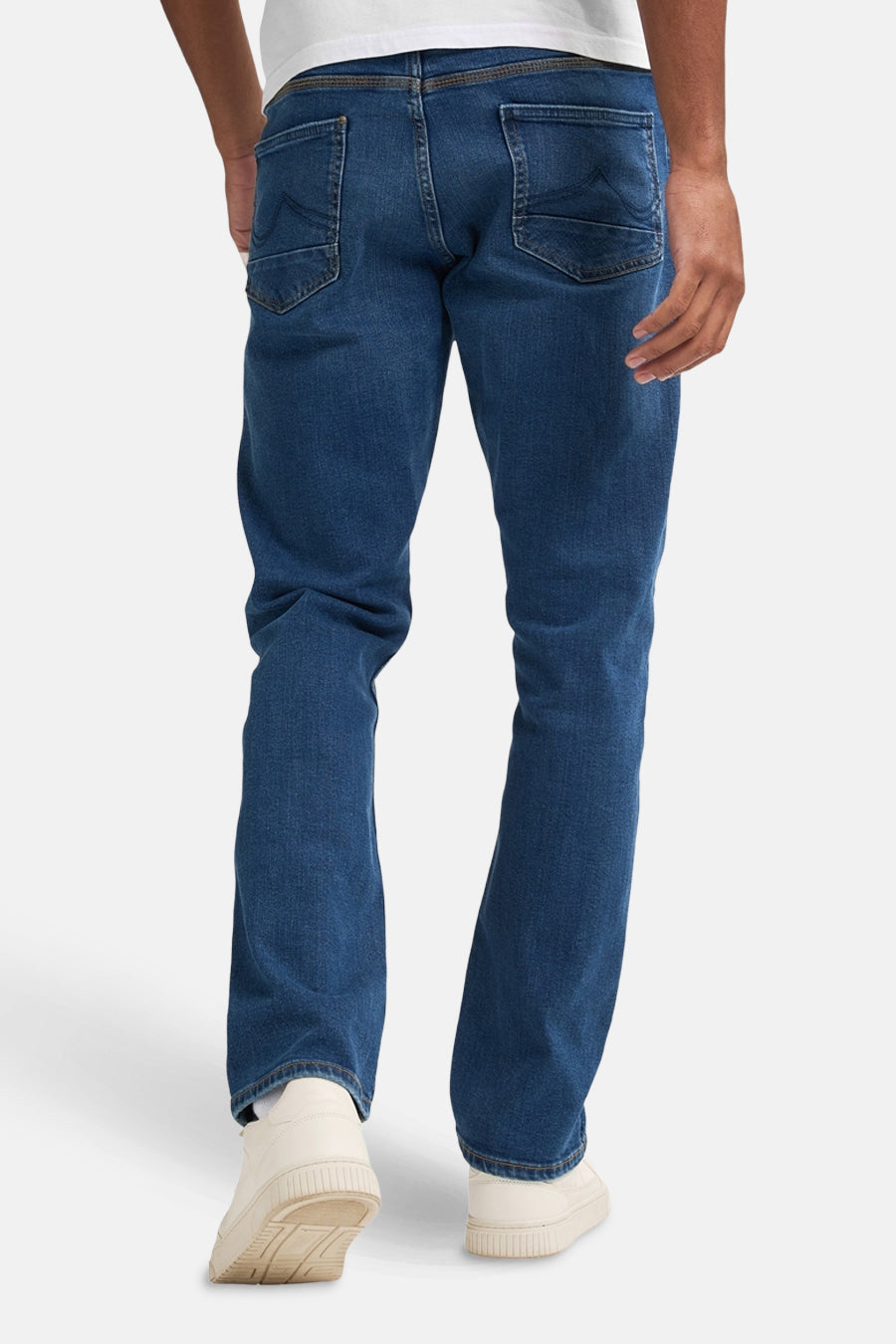 Jean droit bleu moyen de Petrol Industries, vue arrière, porté avec des baskets blanches et un t-shirt blanc.