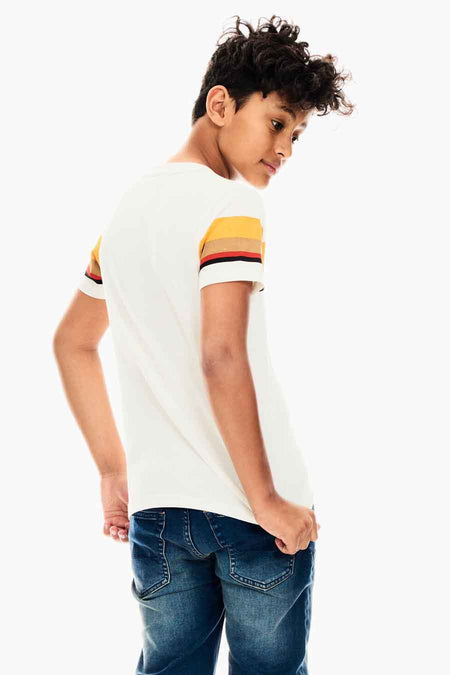 White long-sleeve t-shirt with colorful striped sleeves, worn by a boy in blue jeans, side view