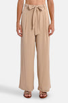 Beige broek van Molly Bracken, losse pasvorm met strikceintuur in de taille, gedragen met sandalen.