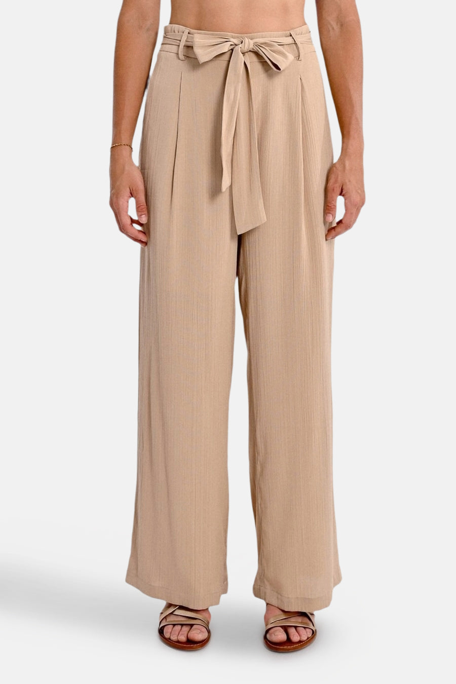 Beige broek van Molly Bracken, losse pasvorm met strikceintuur in de taille, gedragen met sandalen.